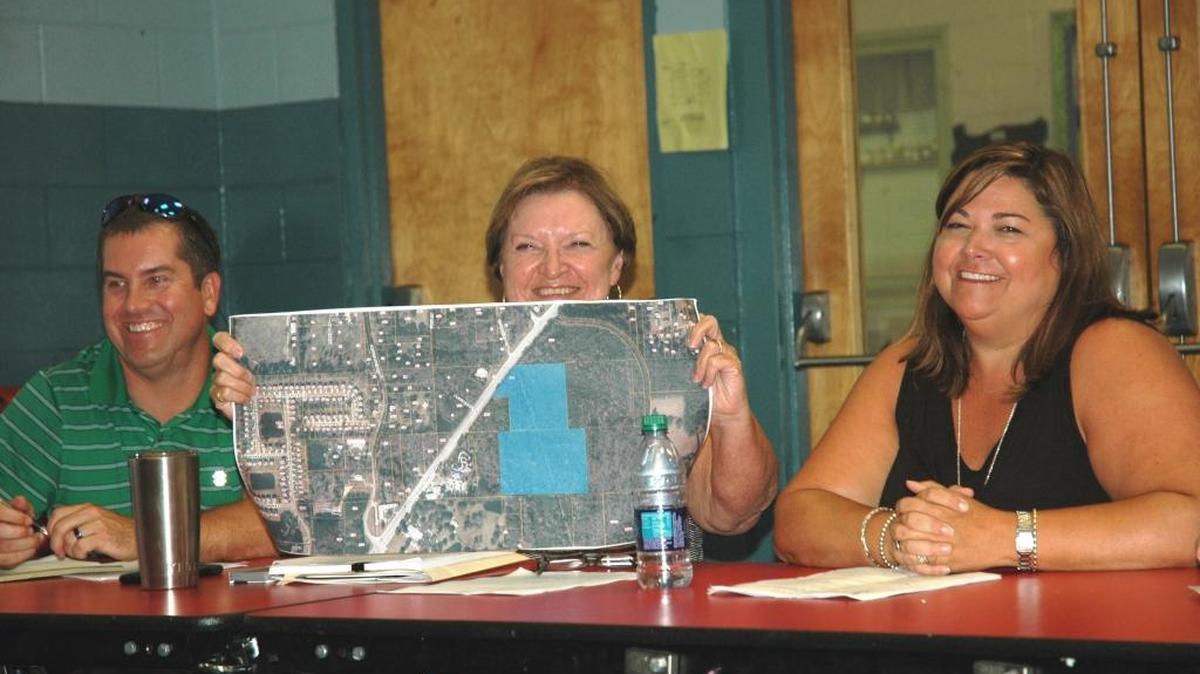 Bridges Preparatory School board members — from left, secretary James Corbin, chair Dee Matthews, and treasurer Caroline Lovell — with site plans for the new Port Royal campus