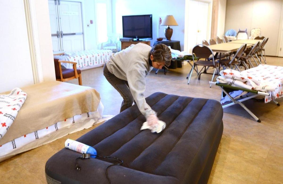 Nancy Pratt, a volunteer from Port Royal, wipes down one of the beds with disinfectant Jan. 9, 2017, while getting ready for the final night of the warming shelter located at Sea Island Presbyterian Church on Lady's Island.
