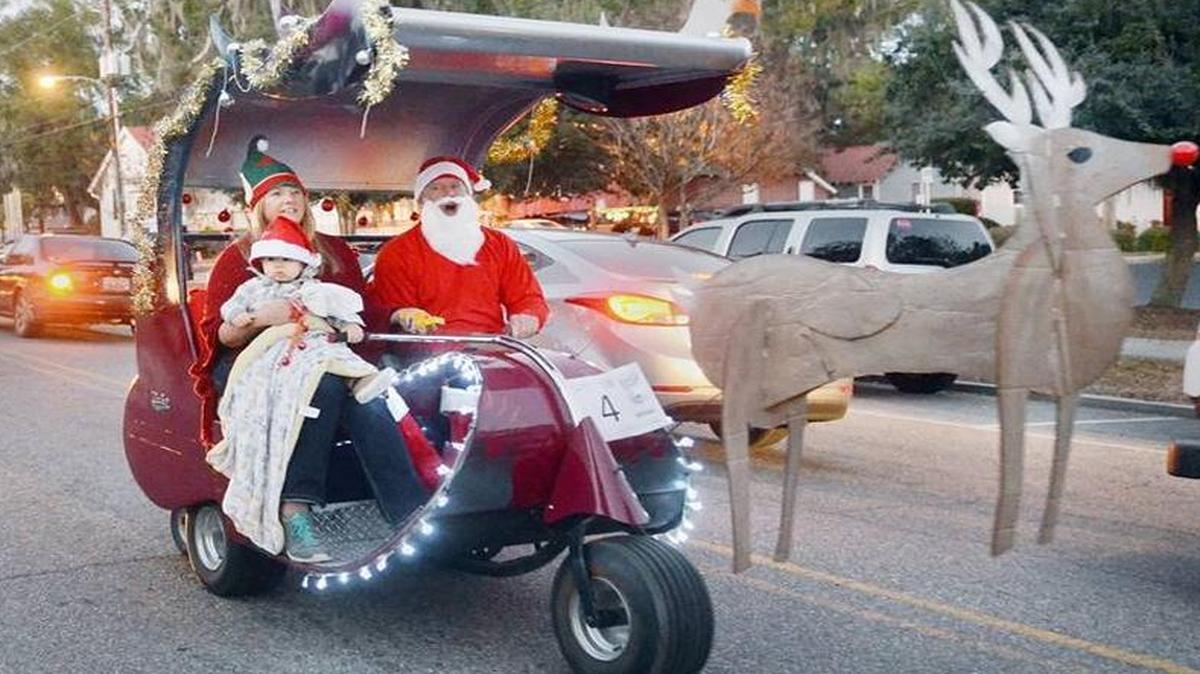 Charlie Finch, Pam Chanay and 11-month-old grandson, Elijah Szarek, ride in a gas powered 1963 three-wheeled golf cart decorated as Santa's sleigh during the fifth annual Port Royal Christmas Golf Cart Parade in 2014.