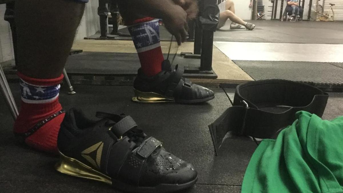 CJ Cummings ties on his pair of Reebok Legacy Lifters on Monday at CrossFit in Beaufort. Cummings was the inspiration for the shoe and consulted on the design.
