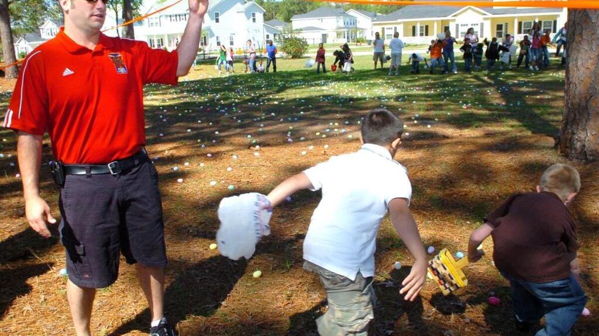 Brett Westerfield holds up a rope and lets a group of children hunt for Easter eggs during the Tri-Command Easter Egg Hunt at Freedom Sound Park in Laurel Bay on April 4, 2009.