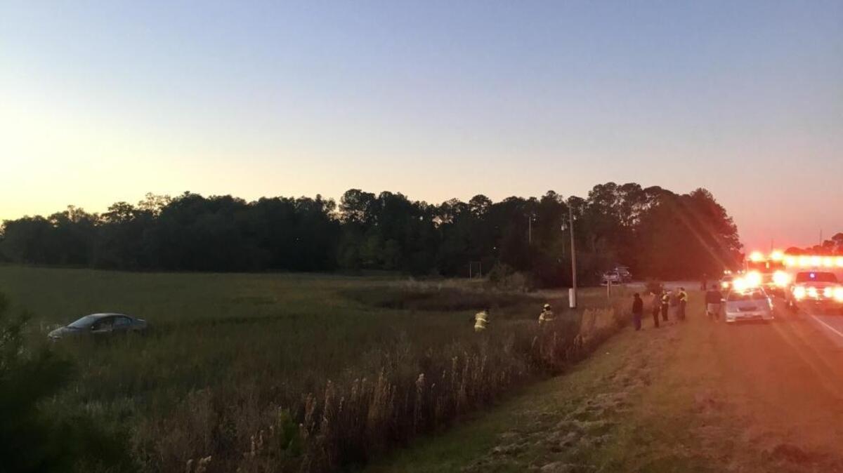 First responders rescue a woman from her car after a wreck left it about 100 feet in the marsh off Trask Parkway near Garret Smalls Road in Burton on Wednesday evening.