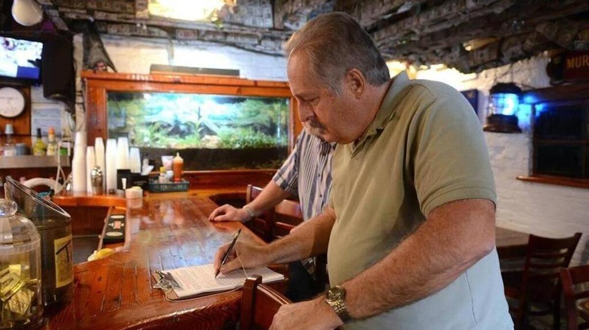 Ed Patrucco, of Lady’s Island, signs a petition in support of Hemingway’s on Feb. 20 in downtown Beaufort.