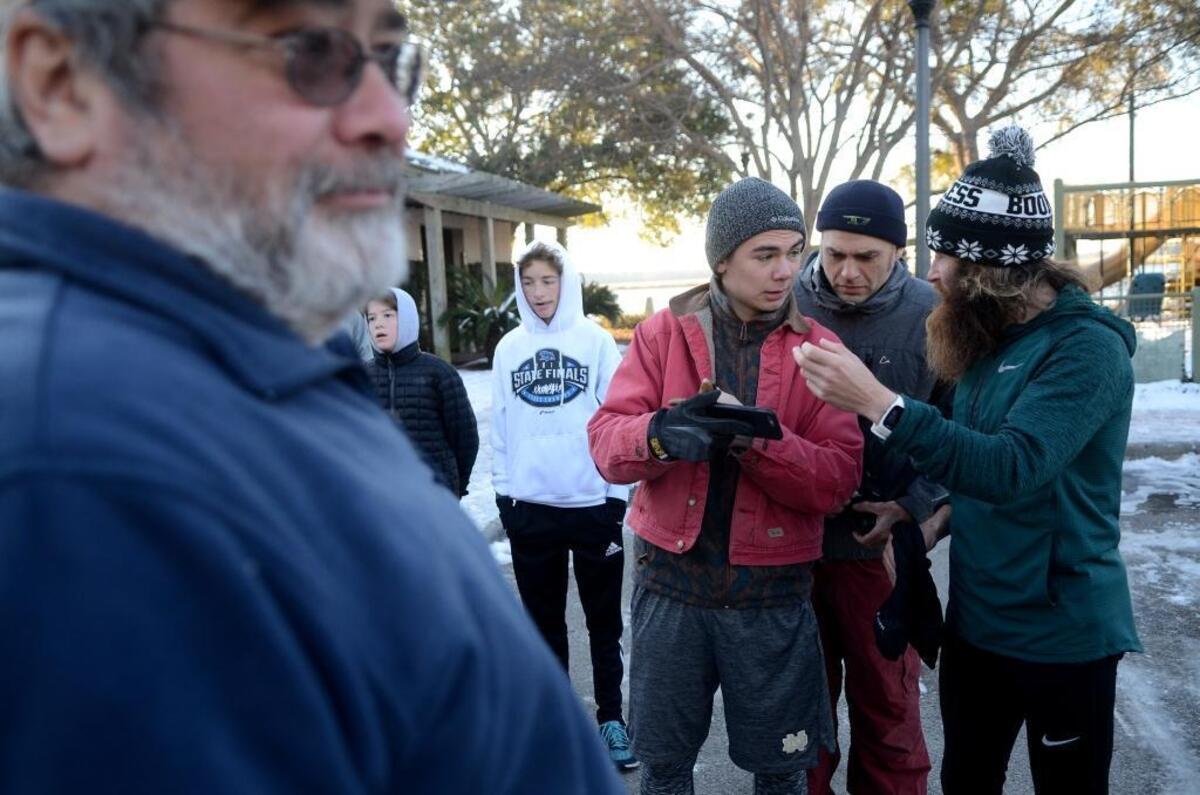 Robert Pope, right, discusses the scene where Forrest Gump runs across Richard V. Woods Bridge with Mathew Nans, left, and Matt Zappia, center, before recreating the scene on Saturday morning in downtown Beaufort.