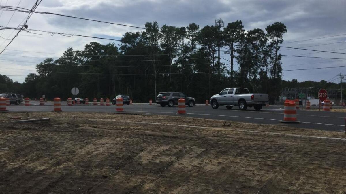 Traffic moves through the intersection of Holly Hall Road and Sams Point Road on Monday. A roundabout is under construction at the intersection and expected to be complete in late August.