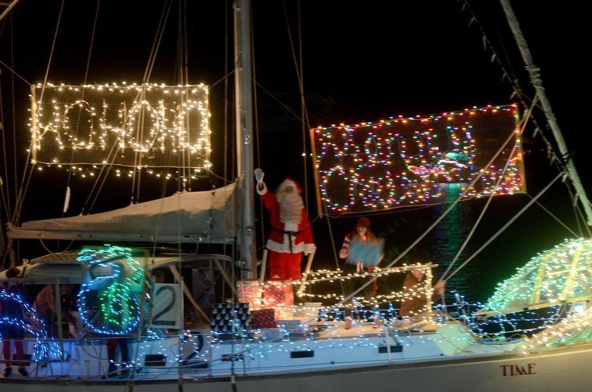 Boats covered in Christmas lights ride by the seawall at Henry C. Chambers Waterfront Park in 2016. This years lighted boat parade is Dec. 7.
