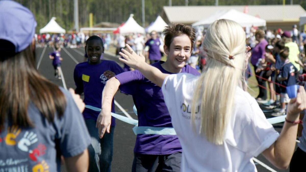 A volunteer prepares to place a winning ribbon around a participant competing in the 100-meter dash on the morning of Friday, April 21, 2017 at May River High School during the Special Olympics South Carolina Area 8 Regional Spring Games. Over 350 students of varying ages competed from Bluffton, Beaufort and Hilton Head Island. There were varying forms of competitions that included, among others, 100-meter, assisted, independent runs and walks and ball throws. The event was in conjunction with Special Olympics and Hilton Head Island based SOAR, a local non-profit that provides activities and recreation for special needs children and adults in the Lowcountry.