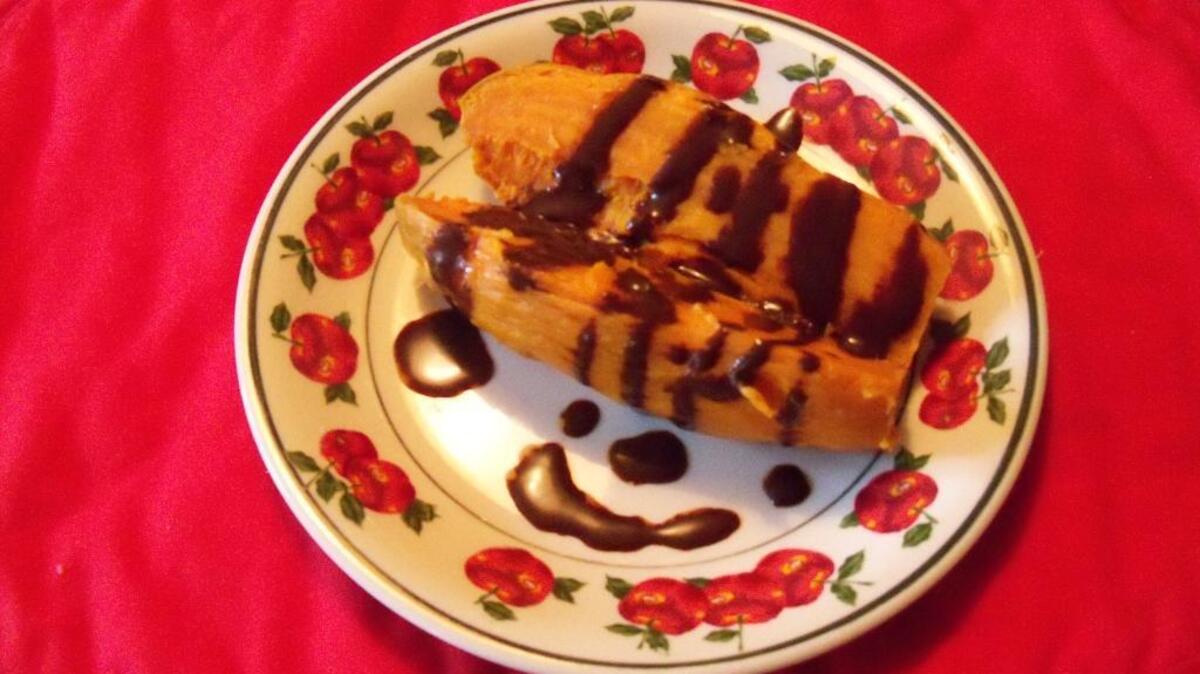A baked sweet potato drizzled with chocolate syrup is a sweet treat.