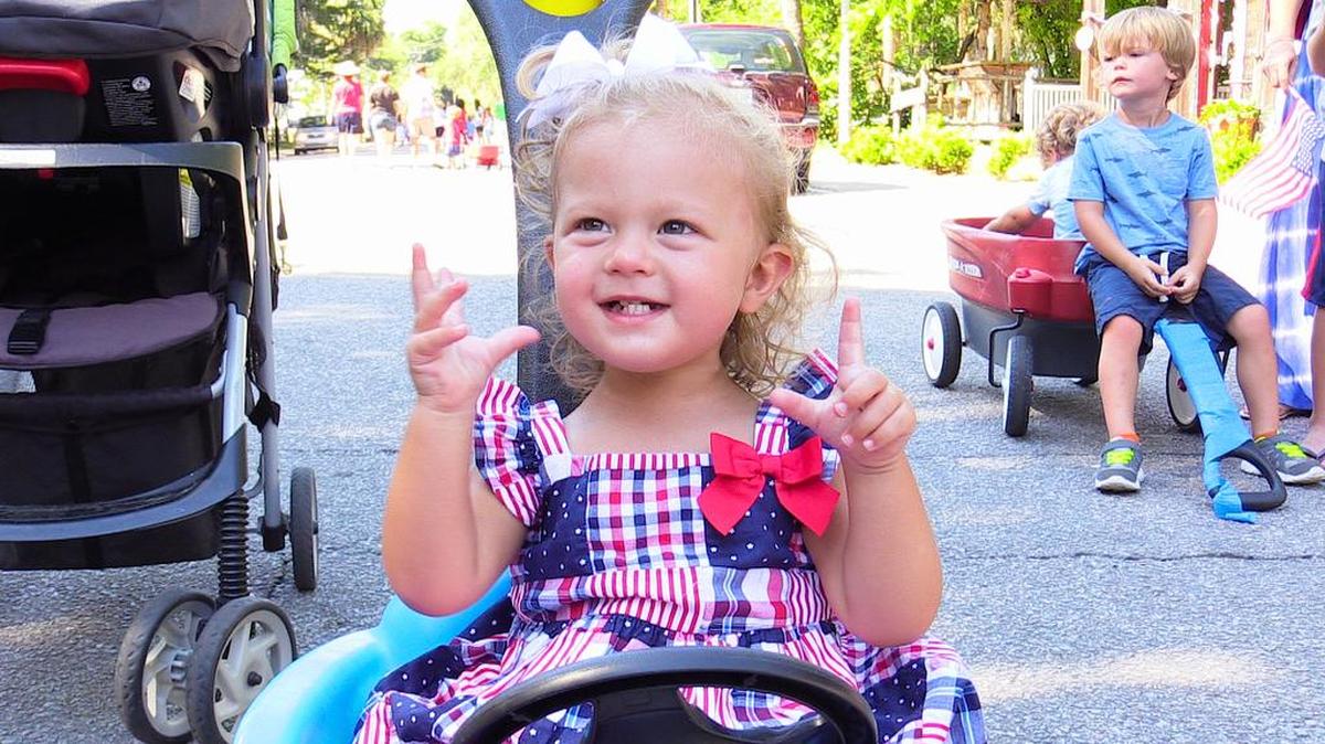 With a little help from her parents, Nolan, 2, of Bluffton, cracks a big smile during the Bluffton 4th of July Parade on Monday in Old Town.