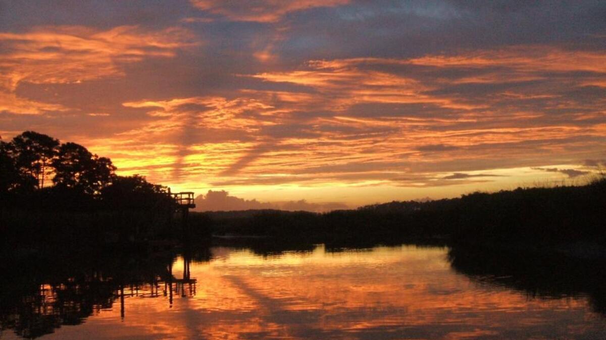 A glorious sunrise hearlds a new day and reflects the river below.