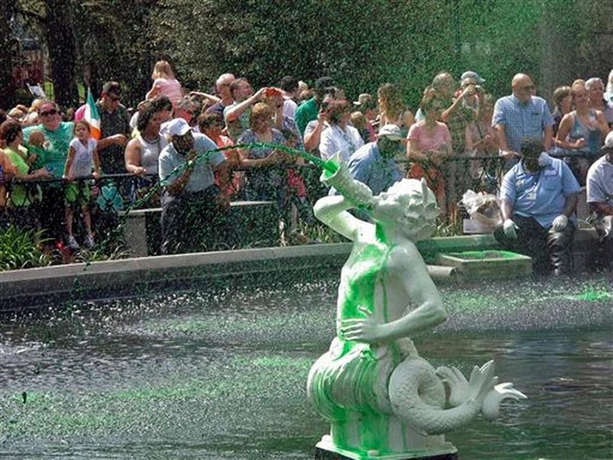 In this Friday, March 11, 2016 photo, a crowd watches as the cast-iron fountain in Forsyth Park sprays water dyed green less a week before the St. Patrick’s Day parade in Savannah, Ga. While dying the fountains in Savannah’s parks is a longstanding St. Patrick’s Day tradition, many visitors believe the city dyes the Savannah River as well. That happened only once in 1961.