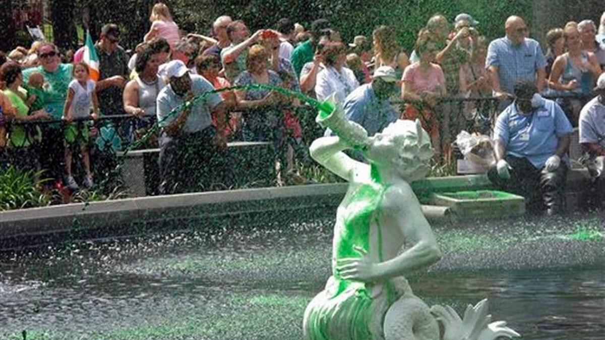 In this Friday, March 11, 2016 photo, a crowd watches as the cast-iron fountain in Forsyth Park sprays water dyed green less a week before the St. Patrick's Day parade in Savannah, Ga. While dying the fountains in Savannah's parks is a longstanding St. Patrick's Day tradition, many visitors believe the city dyes the Savannah River as well. That happened only once in 1961.