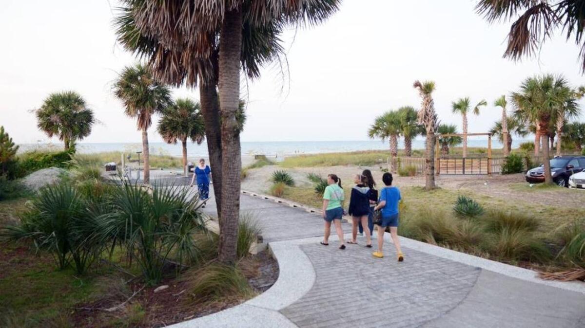 A man says he was attacked after two men yelled racial slurs at him while he walked at Coligny Beach Wednesday.