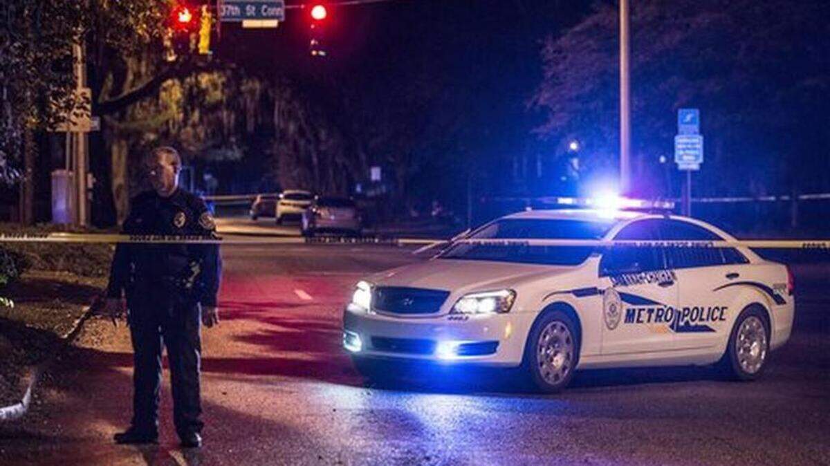 A police officer stands in front of his car early Wednesday morning, Oct. 28, 2015, after a shooting in Savannah, Ga. Authorities are investigating after they say two Savannah-Chatham Metropolitan Police officers and a third person were shot. Police spokeswoman Eunicia Baker says both officers suffered non-life-threatening injuries.