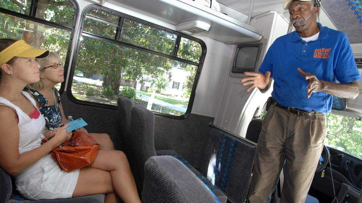From left, passengers Brooke Nation and Anne Benford, both of Atlanta, listen as Gullah Heritage Trail Tour driver and narrator Emory Campbell gives a quick overview of Hilton Head Island history at the start of a bus tour of the island on Wednesday afternoon.