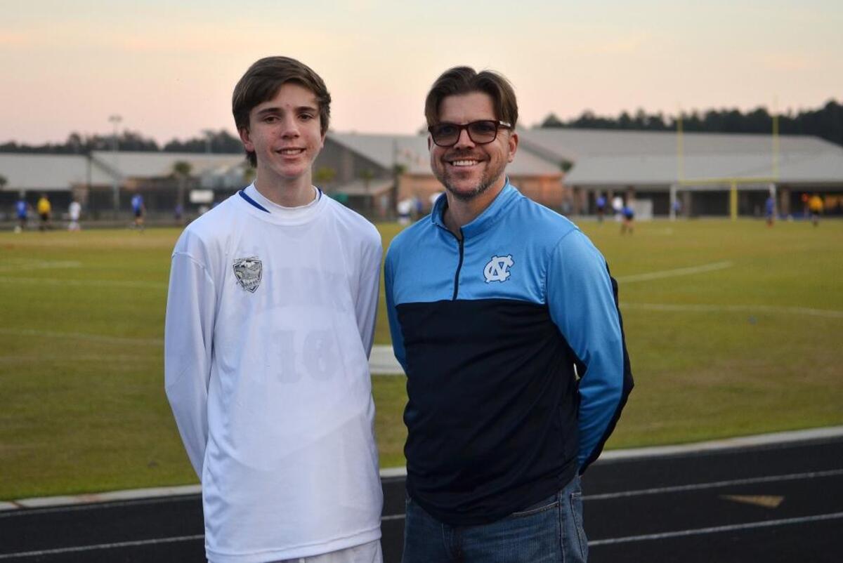 Jackson Stove, 15, and his father Melvin Stove stand for a portrait on Friday at May River High School’s soccer field. Jackson not only plays soccer for the school he also, along with his father, officiates youth sports.