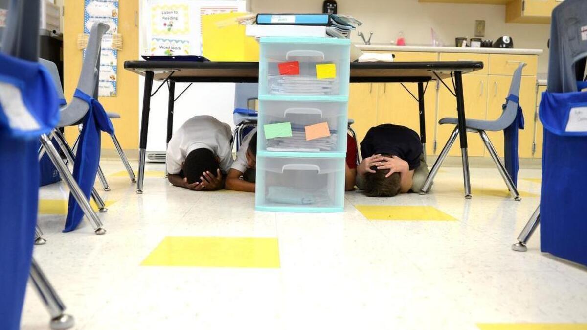 At 10:19 a.m. Thursday morning, first grade students at Okatie Elementary School duck under their tables and cover their heads during the Great SouthEast ShakeOut earthquake drill.