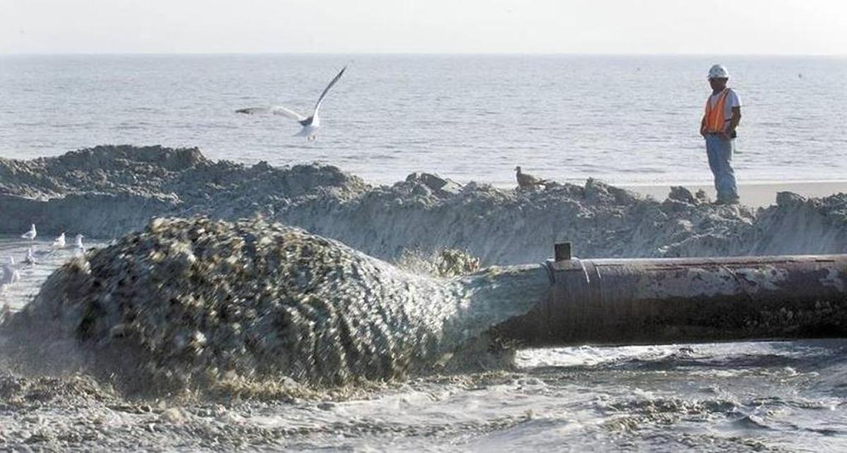 A worker watches as a mixture of sand and water spews from the end of the dredge pipe during a past beach renourishment project on Hilton Head Island.