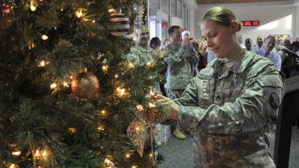 Staff Sgt. Rebecca E. McCumbers, 1st Information Operations Command, affixes the 1st IO Command holiday ornament to the U.S. Intelligence and Security Command Christmas Tree during a special holiday event held by U.S. Intelligence and Security Command leadership at the Nolan Building, Fort Belvoir, Va., Dec. 4, 2012.