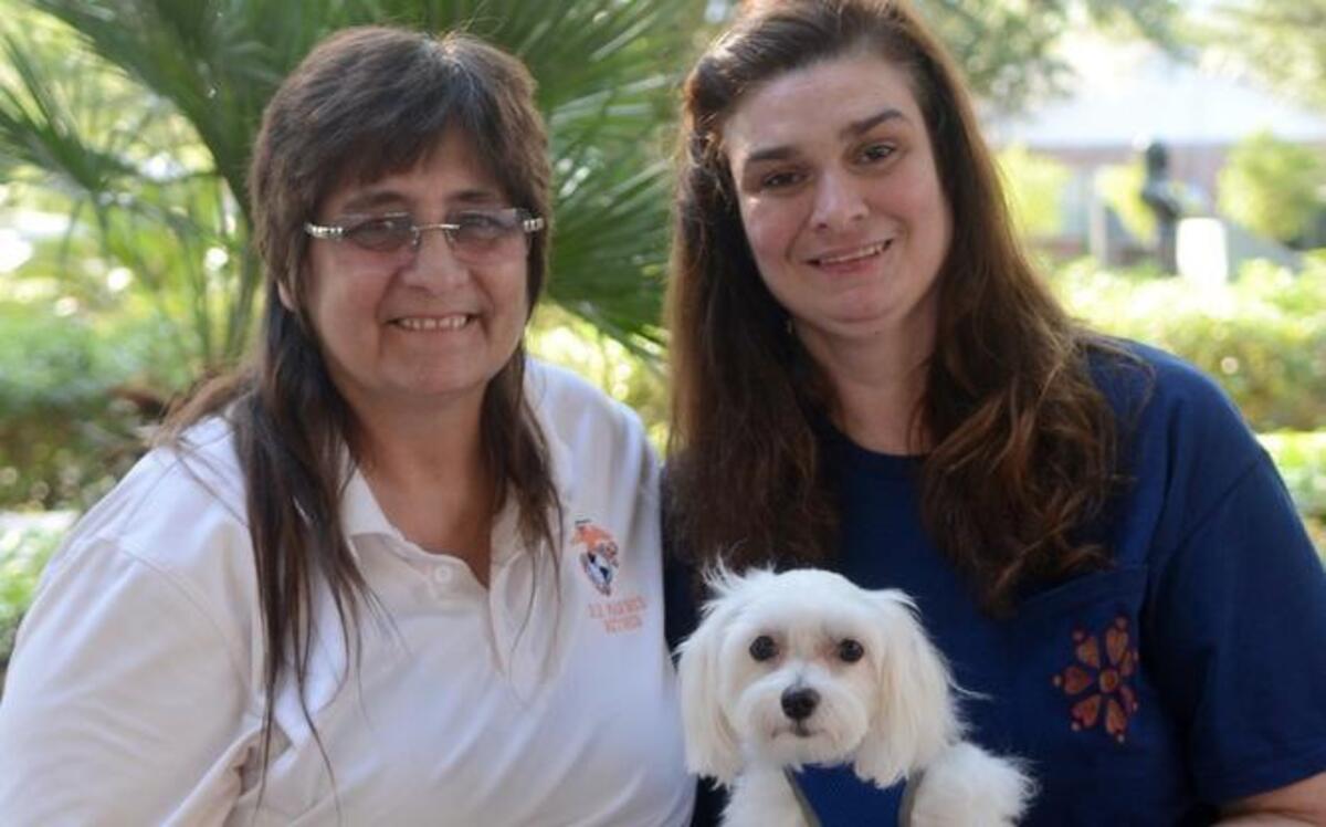 Nina Benedict, left, sits with Emily Thornton and Thornton’s service dog, Lucy, on Tuesday at Henry C. Chambers Waterfront Park in Beaufort.