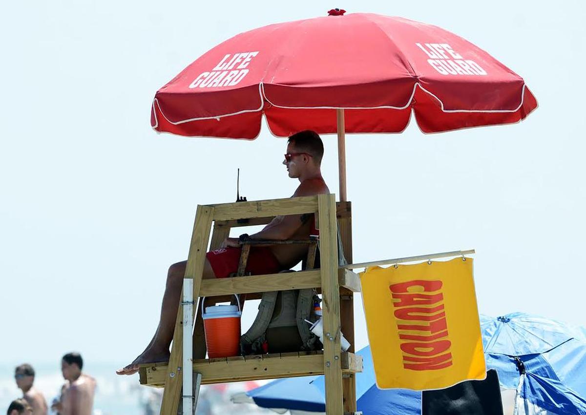 A Shore Beach Service lifeguard flies a caution flag to warn swimmers of strong rip currents at Coligny Beach on Hilton Head Island in this file photo.