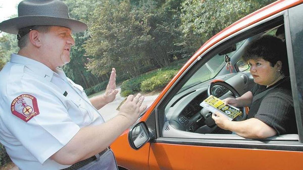 In this file photo, Sea Pines security officer Charles Metropolis gives directions to a motorist entering Sea Pines at the development’s Greenwood Drive security gate.