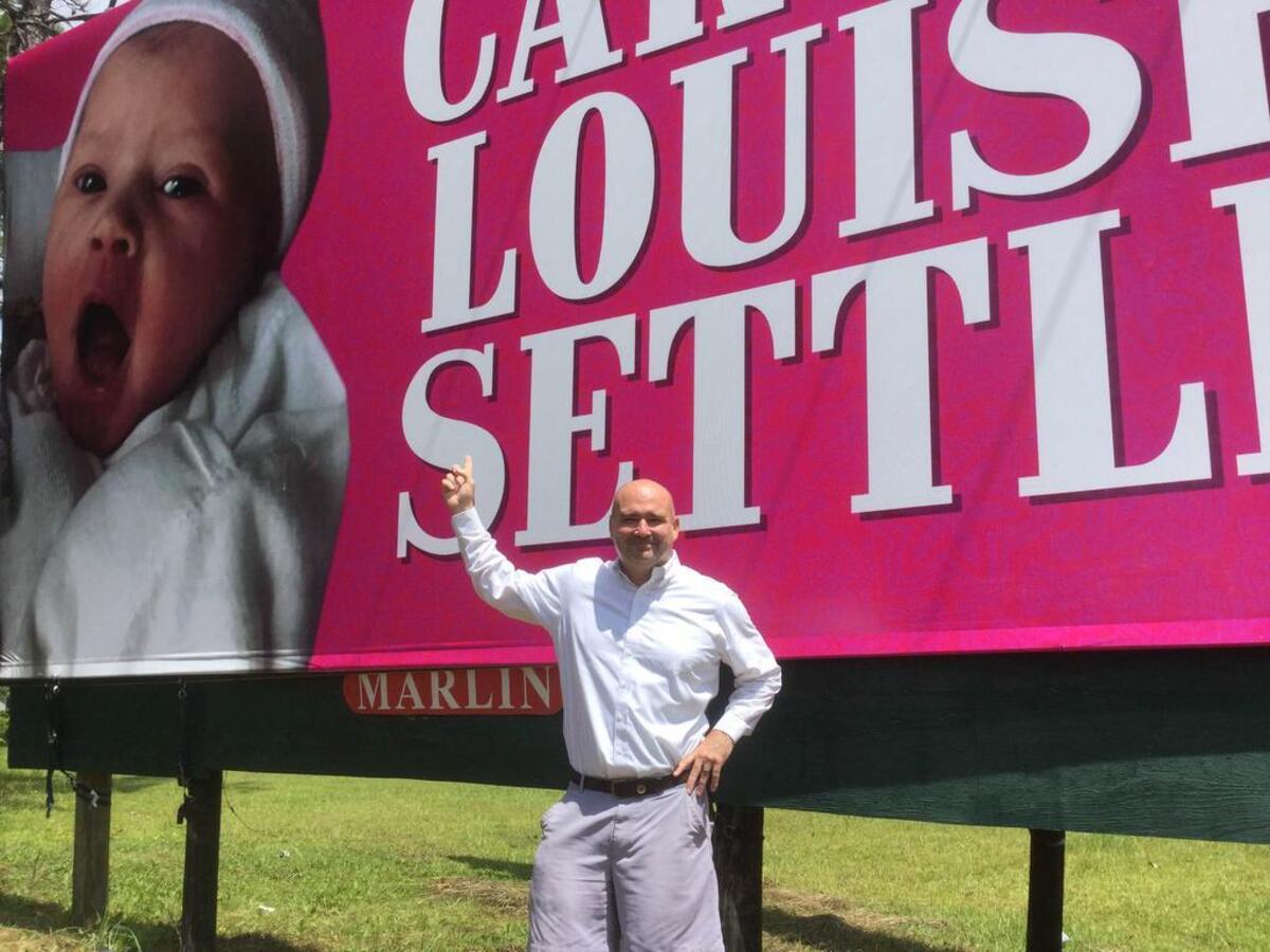 New father Will Settle poses in front of a birth-announcement billboard on Monday, July 3, 2017, in Hardeeville, S.C.’s Levy community. The billboard, a surprise gift from coworkers, pictures Settle’s daughter, Carter Louise Settle.