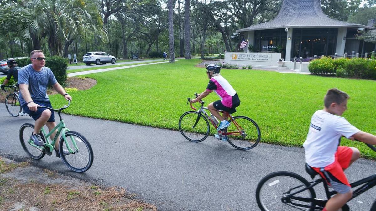 Bicyclists pedal past the Palmetto Dunes Resort's Welcome Center on Tuesday.