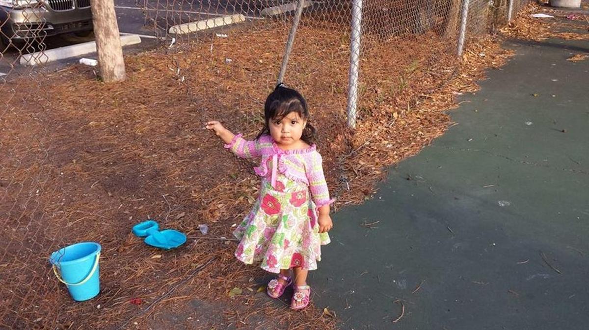 A child plays near a broken fence at the public tennis courts at Cordillo Parkway in March 2015.