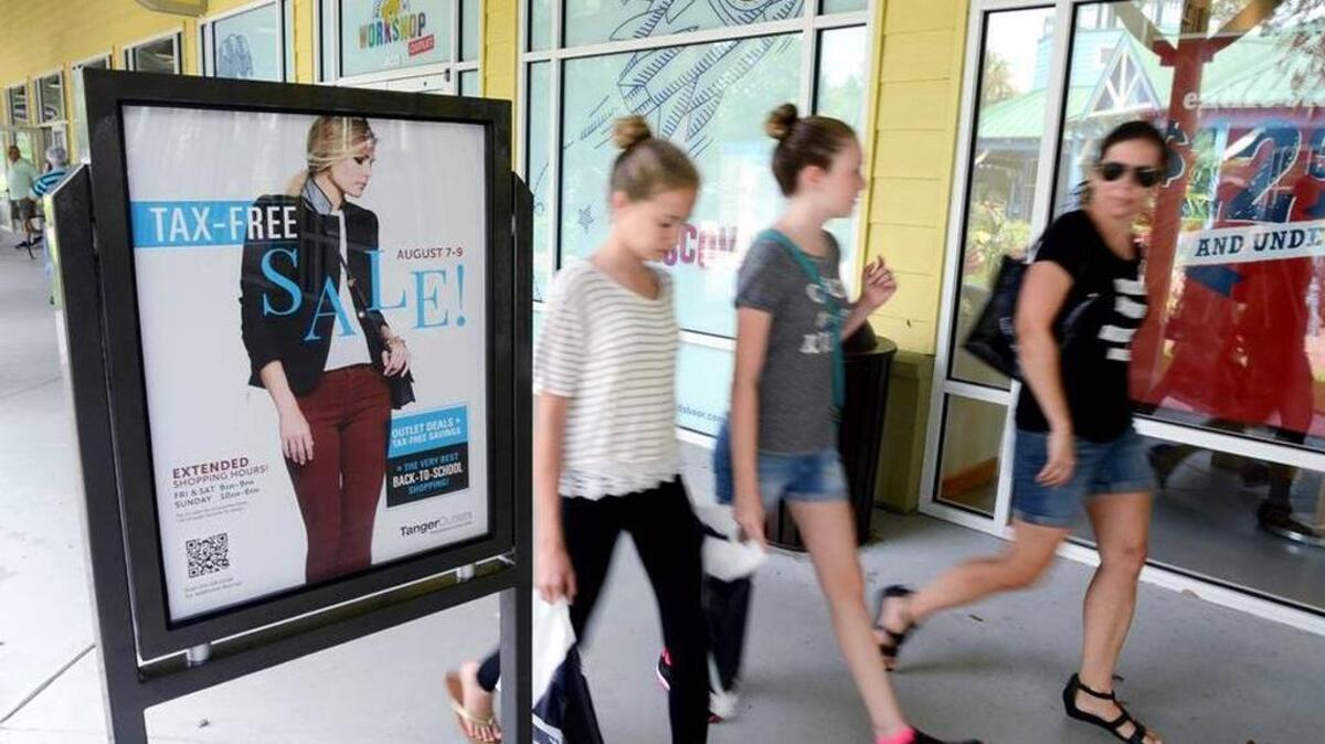 Shoppers at Tanger Outlet Center 2 stroll past a sign advertising sales that were part of South Carolina sales tax holiday weekend for school supplies in 2015. Many items -- but not all -- are exempt from the state’s 6-percent sales tax during the holiday.