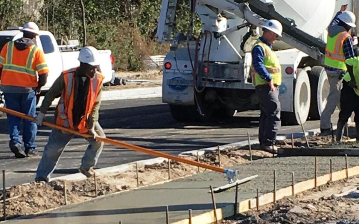 Road crews work to pave First Street and its sidewalk as part of the Boundary Street project. The paving is expected to last through the week of Feb. 13.