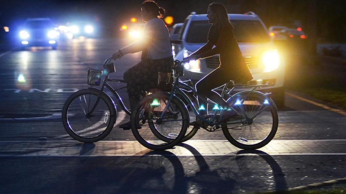 A pair of bicyclists cross Pope Avenue after dark on March 3, 2017.