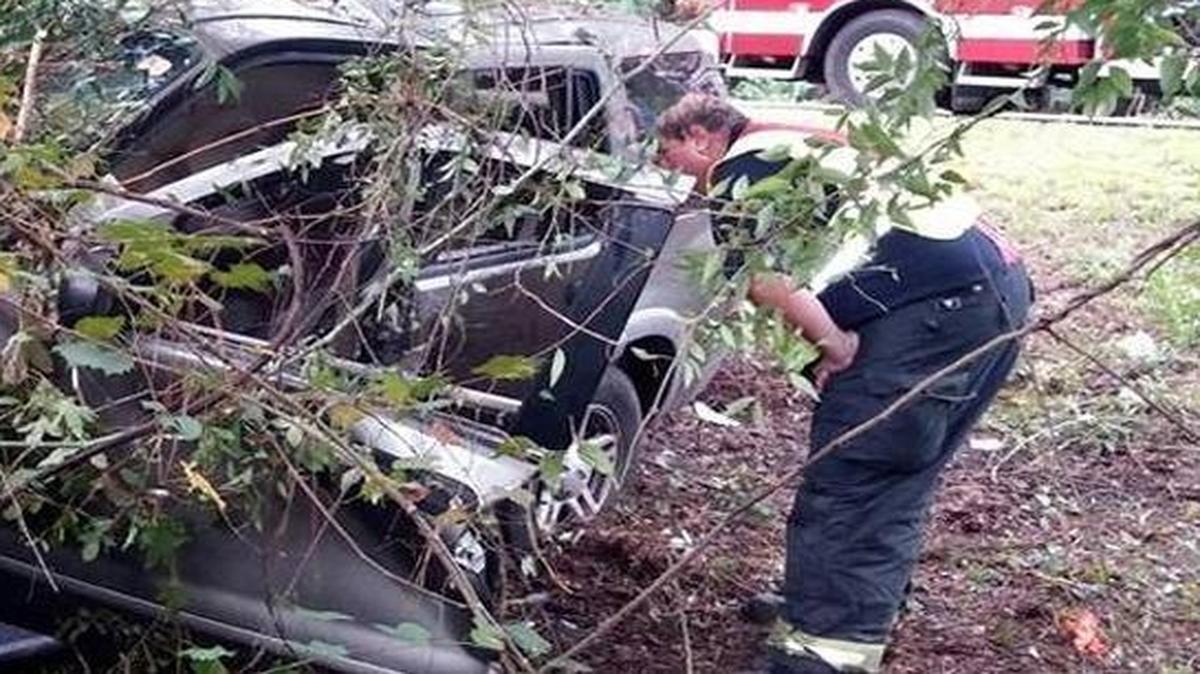 A City of Hardeeville Fire Department employee looks over the wreck of a 2002 Ford minivan that struck trees off the shoulder of I-95 in Jasper County on Sept. 5, 2014.
