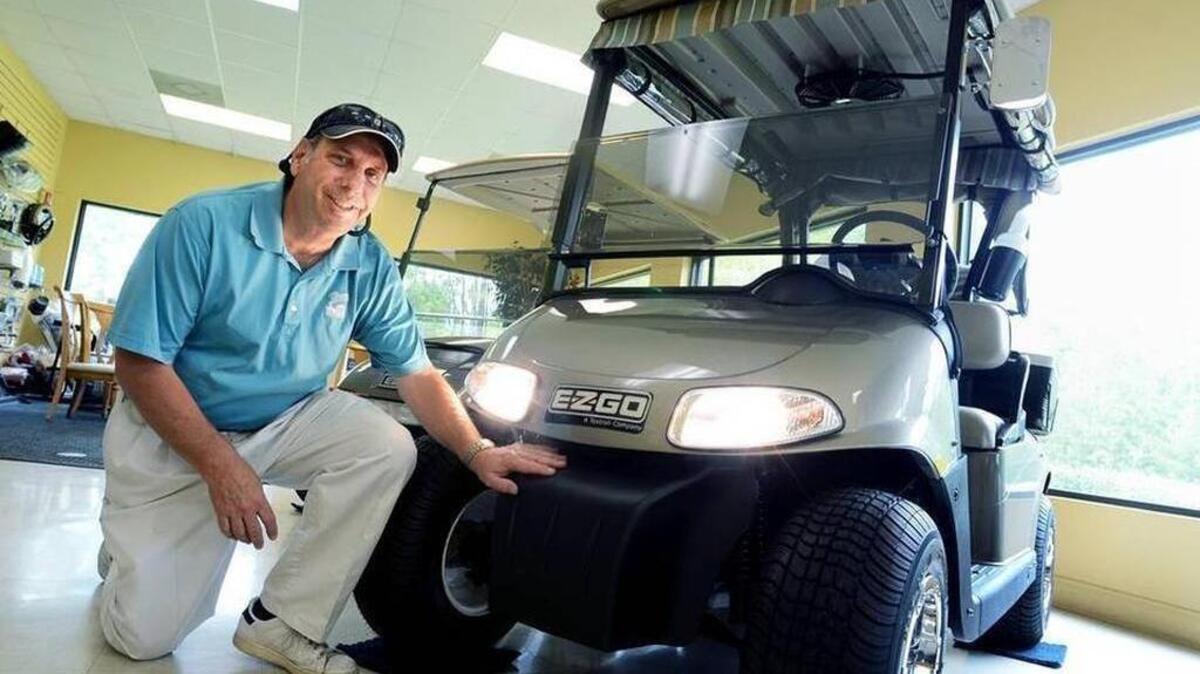 Bob Sutter, of Lowcountry Golf Cars, shows off an E-Z-GO golf cart equipped with headlights at the Okatie dealership.