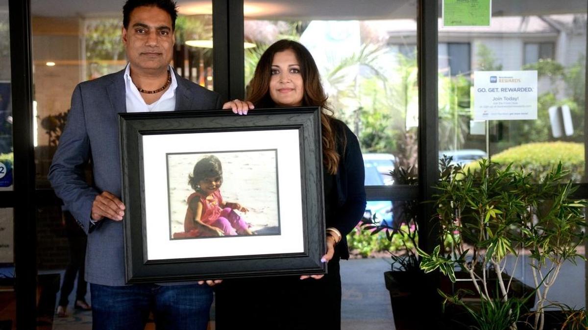Sam, left, and Sandy Johal stand with a portrait of their daughter, Simrit Karam, outside of one of two of their newly renovated hotels on Hilton Head Island. Simrit died at the age of two from Acute Myeloid Leukemia.