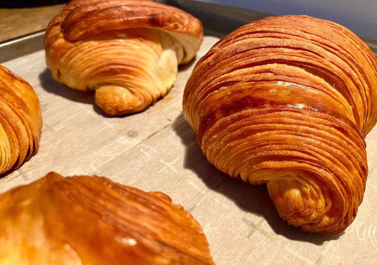 Homemade croissants on a baking sheet.