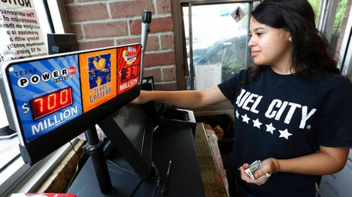 Anahi Medrano sells a Powerball lottery ticket at a convenience store in Dallas Wednesday, Aug. 23, 2017. Lottery officials said the grand prize for Wednesday night's drawing has reached $700 million. The second -largest on record for any U.S. lottery game.