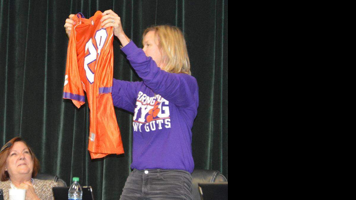 Bluffton Mayor Lisa Sulka holds a Clemson jersey to give to police chief Joey Reynolds at a Bluffton Town Council meeting on Dec. 8 to wear after he lost a bet.