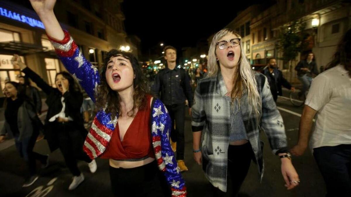 Madeline Lopes, left, and Cassidy Irwin, both of Oakland, march with other protesters in downtown Oakland, Calif., early Wednesday, Nov. 9, 2016. President-elect Donald Trump’s victory set off multiple protests, with a Women’s March on Washington planned for Saturday. (Jane Tyska/Bay Area News Group via AP)