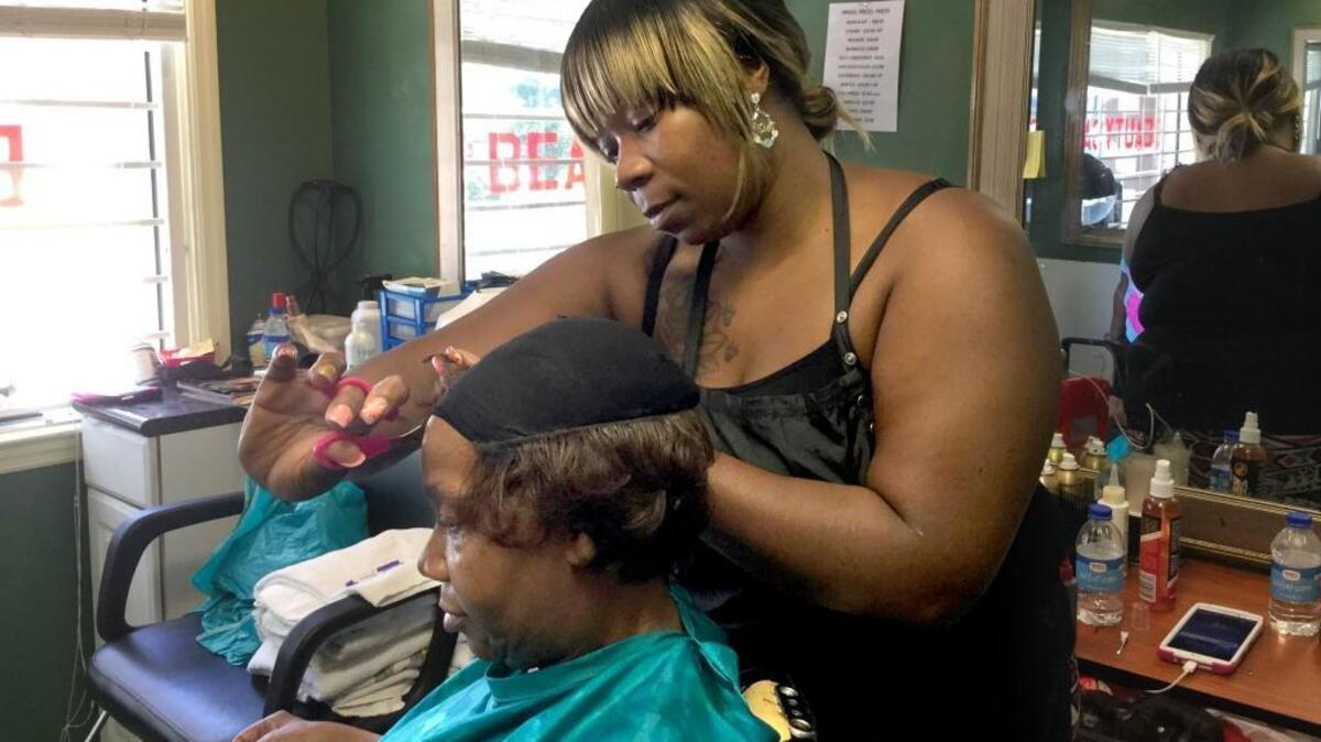 Latasha Dunham styles Barbara Chalmers' hair on July 7, 2016, at Kut-N-Up Barber and Beauty in Hardeeville. Both women say they've seen fewer people sagging their pants in the community. Dunham says that changing fashion trends – not enforcement of a countywide anti-saggy-pants ordinance – explain the change.