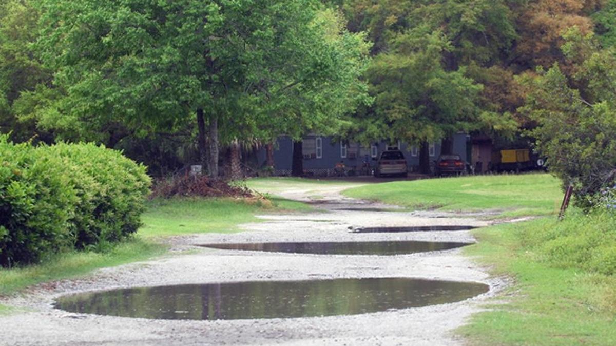Aiken Place, a dirt lane off Marshland Road in 2015, was full of large pools of standing water after heavy rains passed through the area in April of that year.