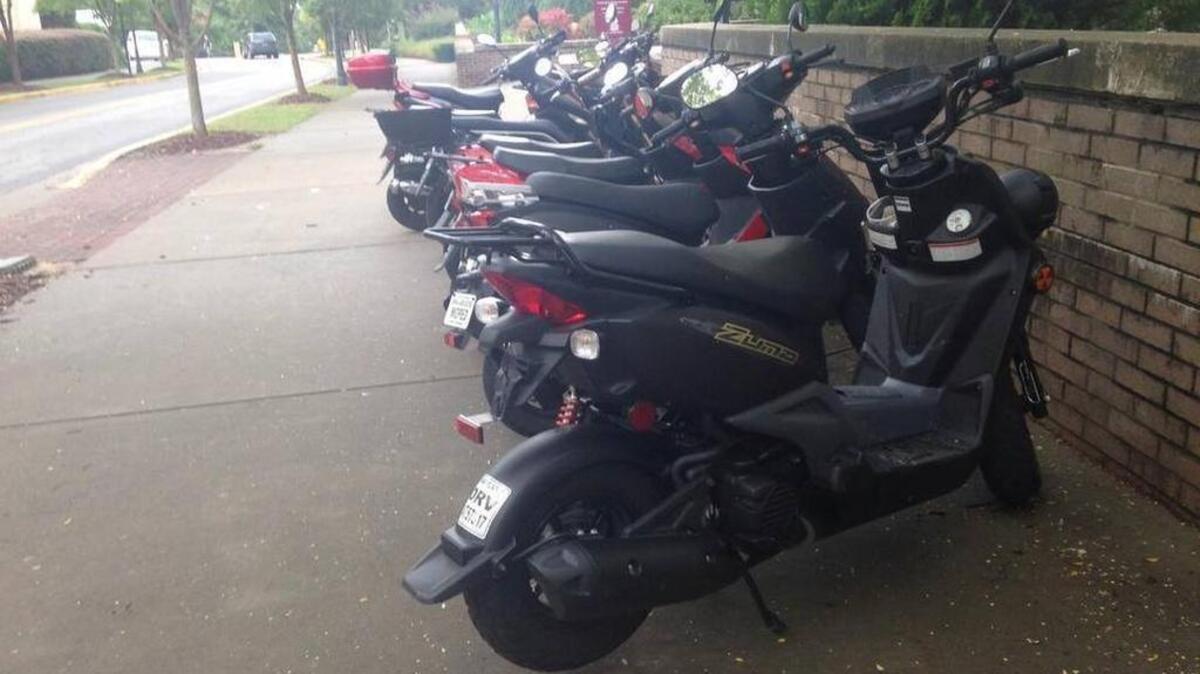 Mopeds are parked at several bike racks on the University of South Carolina’s campus.