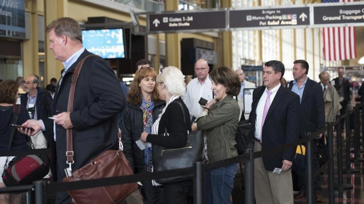 FILE: Passengers wait in a security line at Washington's Ronald Reagan National Airport in Washington on May 13, 2016.