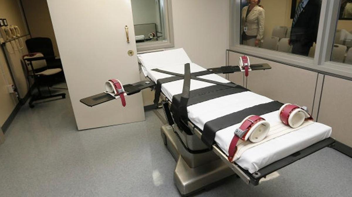 In this Oct. 9, 2014, file photo, Department of Corrections officials are pictured in the witness room at right, outside the newly renovated death chamber at the Oklahoma State Penitentiary in McAlester, Okla. With executions in Oklahoma on hold amid a constitutional review of its lethal injection formula, Republican legislators are pushing to make Oklahoma the first state in the nation to allow the use of nitrogen gas to execute death row inmates.