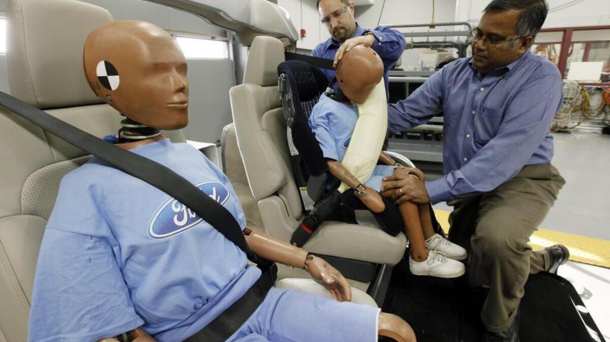 In this photo made Monday, Nov. 2, 2009, Edward DeSmet, left, technical specialist, Global Seatbelts, Body Engineering and Srini Sundararajan, right, technical leader, Passive Safety, Research and Advanced Engineering adjust a crash dummy with an inflatable seat belt on a demonstrator at Ford Motor Co. in Dearborn, Mich. Ford Motor Co. plans to introduce seat belt-mounted air bags in the back seat of the 2011 Ford Explorer sport utility vehicle, which will hit the market next fall. Ford says it's the first automaker to mass produce the technology.