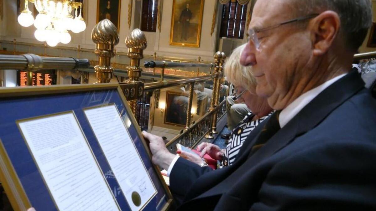 Frank Walker examines the resolution presented to him by the S.C. House of Representatives on March 8, honoring him for his actions in Vietnam that saved the lives of six Marines.