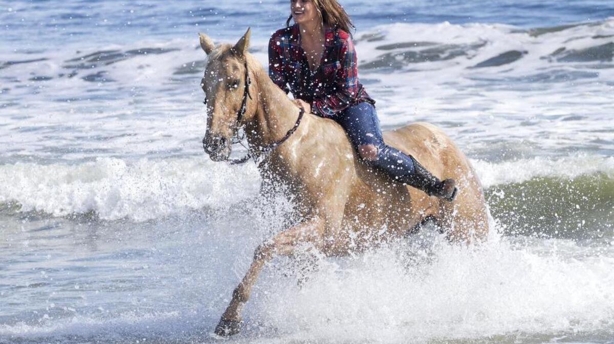 Madison Sitzler of Murrells Inlet rides her horse “Dollar” in the surf at Lakewood Campground.