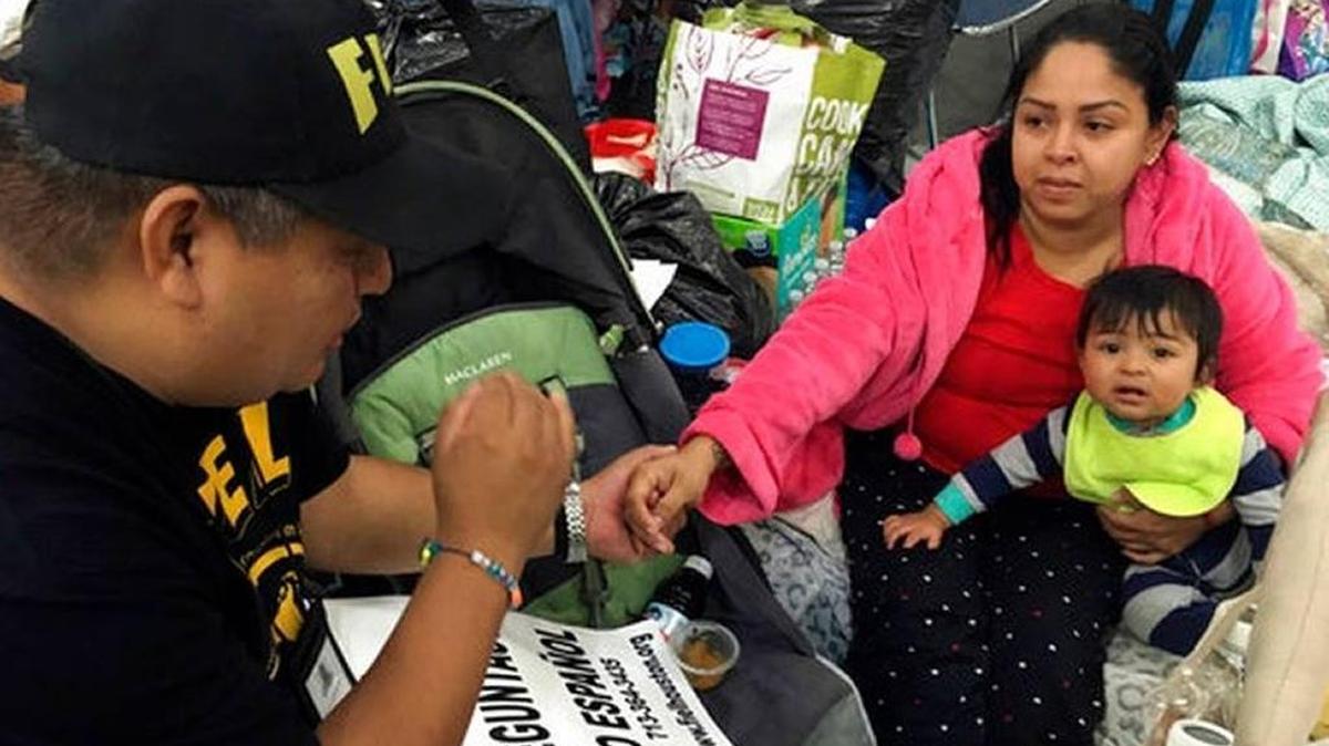 Alain Cisneros, a community organizer for the Immigrant Families and Students in the Struggle, an advocacy group known by its Spanish acronym FIEL, speaks with Adabella Fonseca, a Mexican woman whose parents brought her to the U.S. illegally when she was a year old, with her 10-month-old daughter, as he counsels Harvey evacuees who are in the country illegally at the George R. Brown Convention Center in Houston.