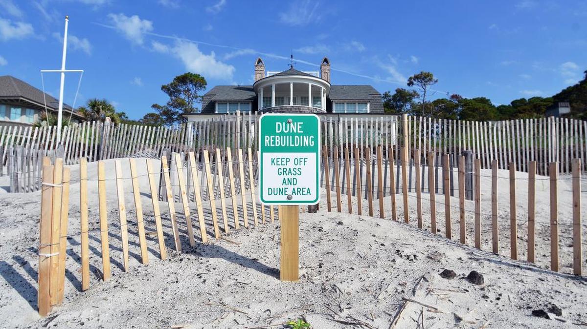 Sand fences have been erected in an attempt to keep a bulldozed berm of sand in place in front of this oceanfront home photographed on Friday along Hilton Head Island’s South Beach near beach emergency call marker 23. The home is one of several that were left hanging over the edge of the surf after Hurricane Matthew eroded away the beach last October. This home is near the center of the South Island Emergency Beach Fill, which will replace the sand washed away by the hurricane and is expected to begin on Aug. 27.