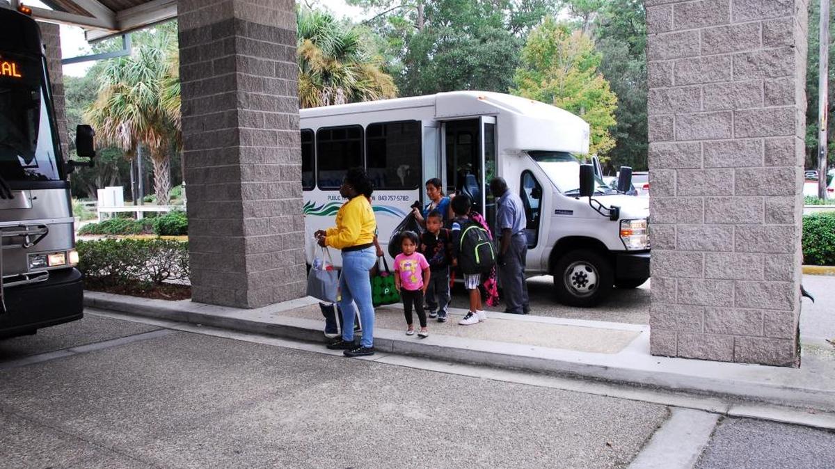 About a dozen people step off a Palmetto Breeze Transit van at Hilton Head Island Airport to board another bus that would evacuate them to Ridgeland-Hardeeville High School on Wednesday, Oct. 5, 2016.